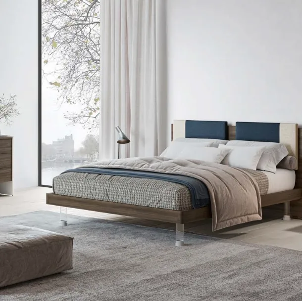 Letto matrimoniale in nobilitato finitura Forestal Dark con testiera rivestita da due cuscini imbottiti in tessuto e piedini trasparenti Ginevra GL14 di Marka Total Living